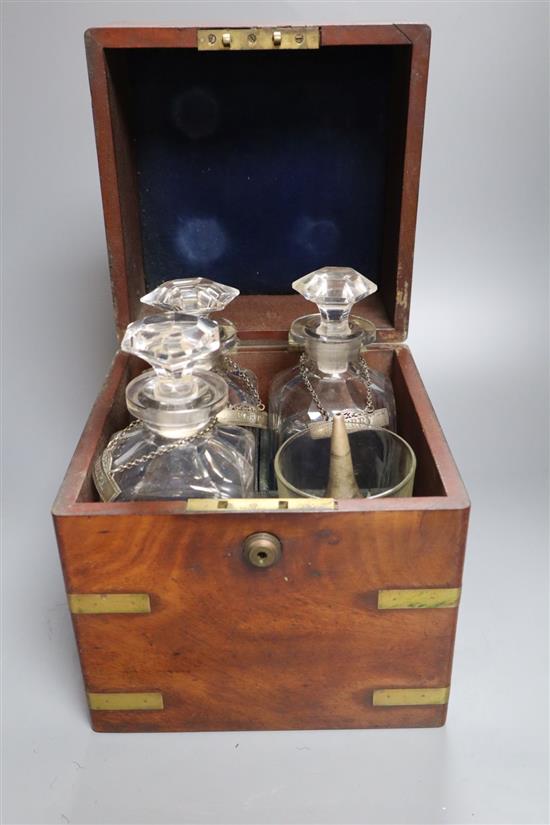 A mid 19th century mahogany and brass bound decanter case, containing three decanters and two associated glasses and a silver plated wi